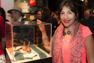 Exposition de LatinArte au Centre d'histoire de Montréal. Une femme se tient à côté d'une vitrine.