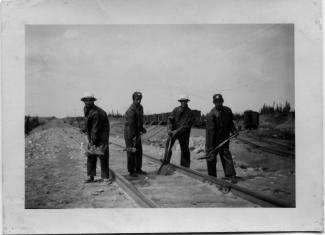 Quatre travailleurs pour une compagnie de chemin de fer en juin 1953.