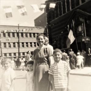 Une femme et ses trois enfants devant l’église italienne Notre-Dame-de-la-Défense. Il y a des gens sur le parvis.