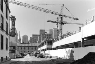 Le Complexe Guy-Favreau en construction, vu de la rue De La Gauchetière. En arrière-plan, l’Église catholique chinoise.