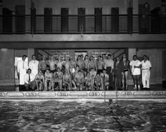 Un groupe d'environ une trentaine d'hommes pose sur le bord de la piscine.