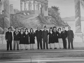Peinture intérieure dans le hall de l’Empress Theatre, devant laquelle posent les employés en 1944. Le décor en arrière-plan représente le kiosque de Trajan au temple de Philae en Égypte.