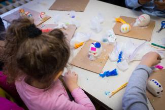 Enfants décorant des crânes pour la Fête des Morts