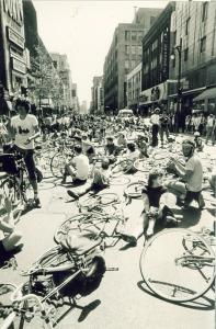 Manifestation de cyclistes sur la rue Sainte-Catherine. Les vélos et les cyclistes sont sur le sol.