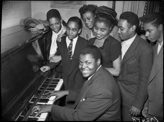 Oscar Peterson au piano, entouré de sa famille.