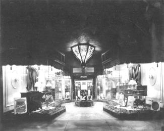 Cette pièce montre des produits Victor vendus chez le détaillant situé au 757-755, rue Sainte-Catherine Ouest, à Montréal. La vitrine contient un Victrola 2-55, des feuilles de musique, des disques du Film The Broadway Melody et une figurine de Nipper.