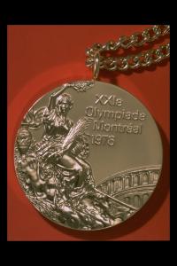 Photographie d'une médaille avec chaîne, avec mention « XXIe Olympiade Montréal 1976 ».