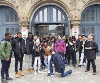 Dix-sept élèves et deux enseignantes prennent la pose devant le Centre d’histoire de Montréal.