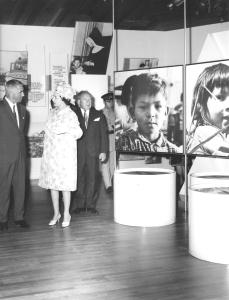 La reine visite le pavillon des Indiens du Canada. On peut voir des photos présentés dans l'exposition.