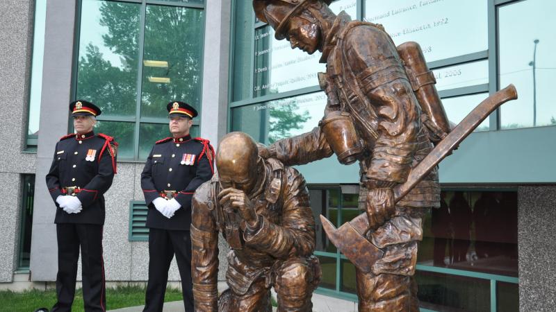 La garde d’honneur du SIM devant le monument en hommage aux pompiers décédés du Québec