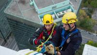 Deux pompiers au sommet d'un édifice lors d'une simulation de sauvetage en hauteur. 