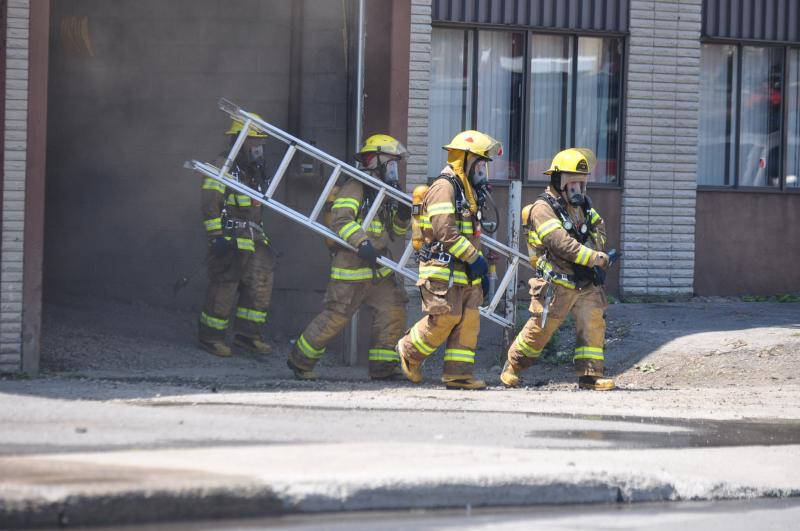 Quatre pompiers sur les lieux d'un incendie.