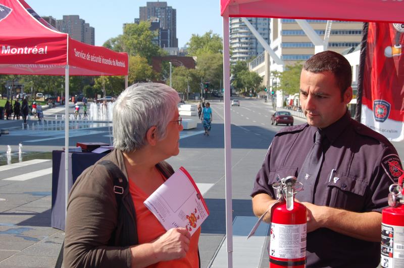 Un agent de prévention du SIM informe une citoyenne lors du lancement du Mois de la prévention des incendies.