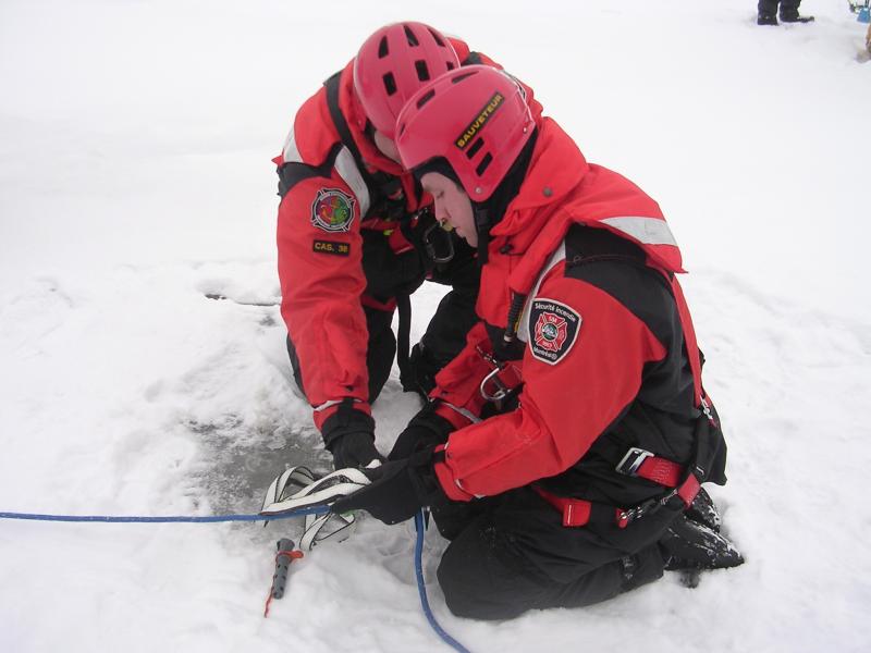 Two firefighters-rescue workers during an ice rescue simulation 