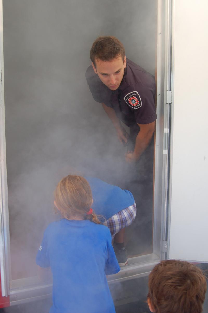 Coached by a fire safety educator, children evacuate the SIMulateur amid non-toxic smoke. 