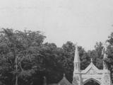 L’entrée du cimetière Mont-Royal, avec le portail à droite et la résidence du régisseur à gauche, entourés d’arbres.