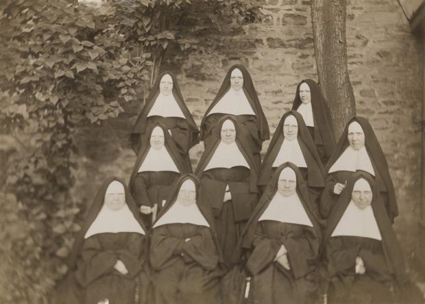 Un groupe de 11 Religieuses Hospitalières de Saint-Joseph de Montréal disposées en rangées pose dans le jardin du monastère en 1903.