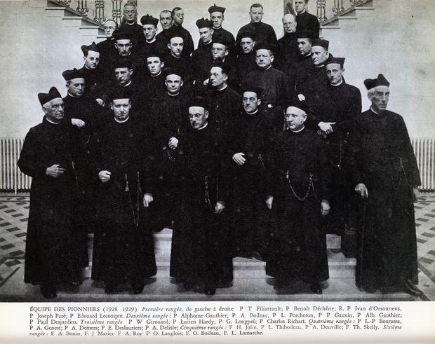 Groupe de 30 jésuites posant dans les escaliers du collège, répartis en 5 rangées.