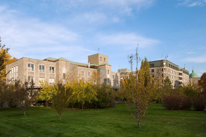La façade arrière du bâtiment offre une vue sur le jardin, sur le parc Jeanne-Mance et sur le mont Royal.  Photographie.