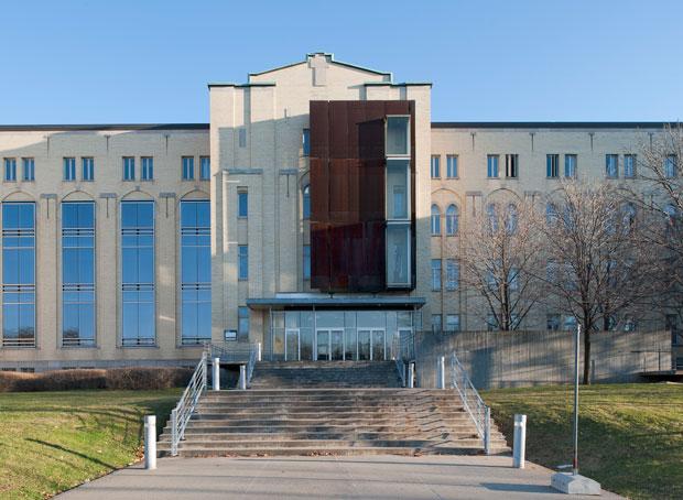 Élévation principale du pavillon de la Faculté de l’aménagement. À la suite de l’acquisition du bâtiment par l’Université, des modifications ont été apportées aux fenêtres à gauche et un élément en acier corten a été ajouté au-dessus de l'entrée. Photo.