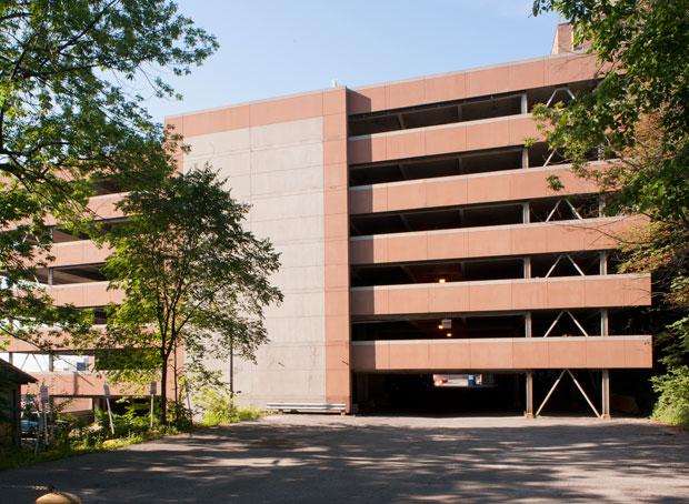 Le stationnement de l’Hôpital général de Montréal. En raison de la présence de bâtiments réduisant l’espace disponible et des particularités dues à l’escarpement du mont Royal, le choix de construire un bâtiment en hauteur, de  sept étages, a été retenu. 