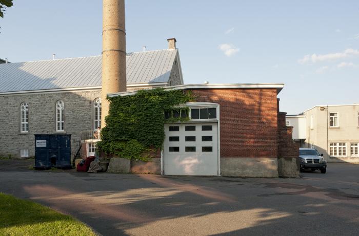 L'entrepôt à charbon présente des éléments architecturaux liés à ses fonctions, comme de larges portes nécessaires aux manœuvres. Photographie.